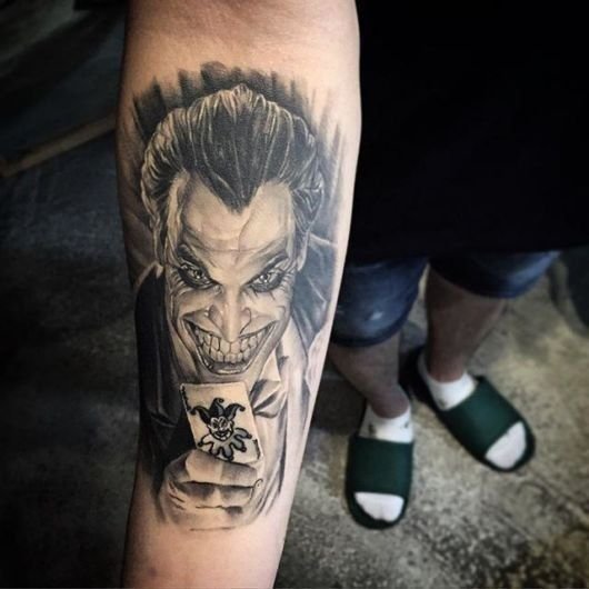 hình xăm joker cầm lá bài trên tay