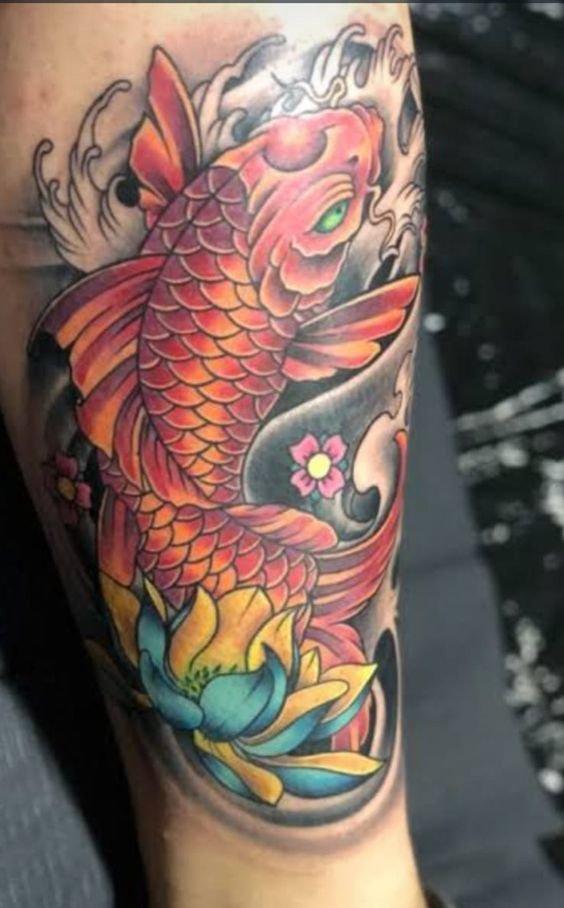 tattoo đỏ cá chép phối hoa sen xanh vàng trên cánh tay