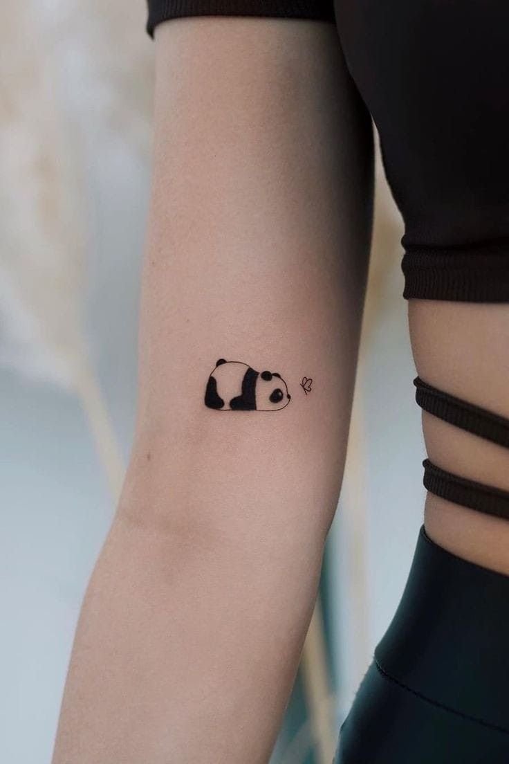 mini sleepy panda tattoo on female upper arm