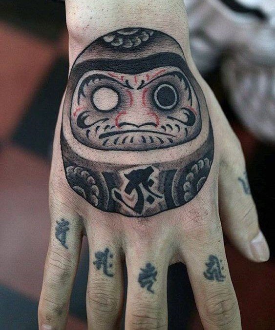 xăm hình daruma một bên mắt trên mu bàn tay nổi bật