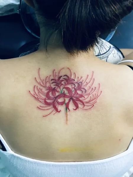 H&igrave;nh xăm hoa đỏ tr&ecirc;n vai người, thiết kế chi tiết v&agrave; sắc n&eacute;t.