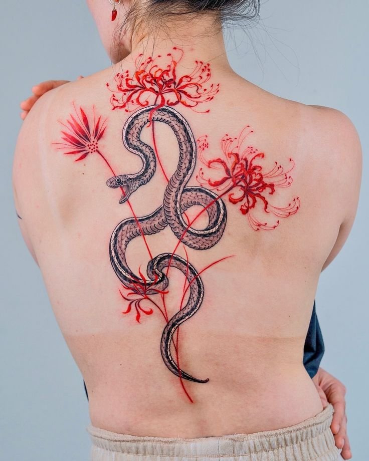 H&igrave;nh xăm sau lưng với h&igrave;nh rắn v&agrave; hoa đỏ nghệ thuật, nổi bật tr&ecirc;n nền da s&aacute;ng.