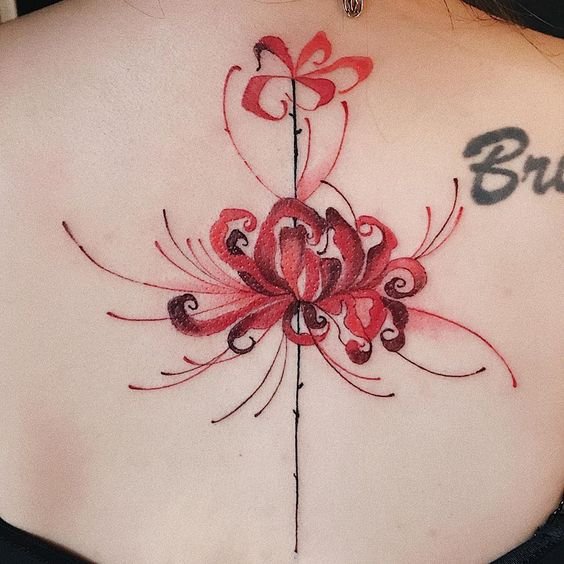 H&igrave;nh xăm hoa văn đỏ v&agrave; đen tr&ecirc;n lưng, với chữ c&aacute;i m&agrave;u đen b&ecirc;n phải.