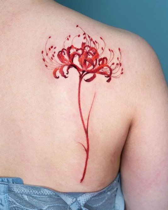 H&igrave;nh xăm hoa đỏ tr&ecirc;n vai người, thiết kế chi tiết với c&aacute;nh hoa mảnh mai v&agrave; m&agrave;u sắc nổi bật.